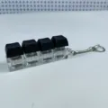 Dettaglio del portachiavi fidget con 4 tasti meccanici luminosi e copritasti neri - Stile a Quattro Tasti con Copertura Spessa / Con Luce / Nero