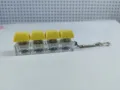 Dettaglio laterale di un portachiavi antistress a 4 tasti con tasti gialli e interruttori - Stile a Quattro Tasti con Copertura Spessa / Con Luce / Giallo