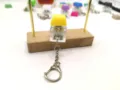 Close-up of a mechanical keyboard switch keychain with a yellow keycap for stress relief - Yellow