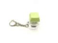 Close-up detail of a glowing mechanical keyboard keycap fidget toy keychain on white background - [with light] matcha green