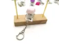 Detailed close-up of a high-transparency mechanical keyboard switch keychain with pink keycap - Light Pink