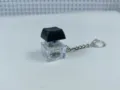 Mechanical keyboard switch keychain with clear base and black keycap for stress relief. - 012