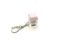 Detailed close-up of a pink mechanical keyboard switch keychain with transparent base - [with light] light pink