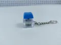 Close-up detail shot of the glowing mechanical keyboard switch keychain with blue keycap. - 015