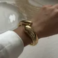 Close-up detail of a chunky gold-tone smooth waterdrop wrap bracelet on a wrist - Smooth Water Drop Wrap Cuff