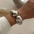Primo piano di un bracciale rigido ovale in argento lucido con design a doppia goccia - Stile a Doppia Goccia d'Acqua (213) / Argento