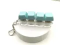 Mechanical keyboard switch fidget keychain with blue keycaps and transparent base for stress relief. - 4-Key Luminous / Light Blue