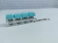 Detail view of the four-key mechanical switch keychain featuring clear housing and blue keycaps. - Four-Key Thick Cover Ordinary Chain / No Light / Cyan