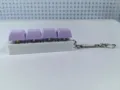 Side detail of a white mechanical keyboard keycap keychain with four purple buttons toy. - Style 17 / 4 Keys Without Light