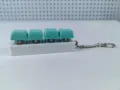 Close-up of 4-key mechanical keyboard switch keychain with cyan keycaps and white base. - Cyan Style (Model 26) / 4 Keys Without Light