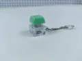 Transparent mechanical keyboard switch keychain detail, glowing fidget toy with green keycap. - 026