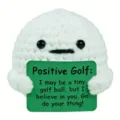 Primo piano di una bambola da golf all'uncinetto con un biglietto motivazionale 'Positive Golf'. - Pallina da Golf (Positivo)