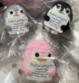 Handmade crochet penguin plush toy detail showing cute design and encouraging positive card. - Penguin