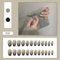 Detailed view of French V-tip press-on nails in nude and black almond shaped design - R161 Western French Style / Glue Type