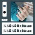 Detailed close-up of matte navy blue and cow print press-on nails set for manicure - R172 Leopard Puppy / Glue Type