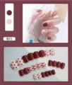 Detailed view of burgundy and cream false nails with polka dots and cross patterns. - Red Ribbon Style (R013) / 24Pcs Set (Glue Style) / Red Straps