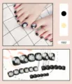 Detaillierte Makroansicht schwarzer künstlicher Zehennägel mit weißem Gänseblümchen-Design - 24er Set (Inklusive Kleber) / Schwarz Gänseblümchen Stil (F002)