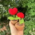 Handgemachte gehäkelte Topfpflanze Detail mit roter Herzblume und grünen Blättern. - Kleiner Topfpflanze mit rotem Herz (links)