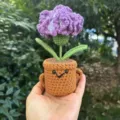 Handgemachte Häkel-Topfpflanze Detail, süße lila Blume mit braunem Gesichtstopf, Deko. - Lila Nelken-Topfpflanze