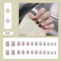 Detailed macro shot of R197 French style press-on nails with beige and pink abstract patterns - R197 Shimmering Milky White / Glue Type