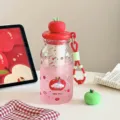 Cute apple-themed tea infuser water bottle with portable lanyard on white table - 8015 Red Apple Lid