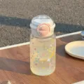 Detailopname van een transparante plastic waterfles met gekleurde sterren en roze dop. - [PC] Roze - [Dual-Drink planeet]