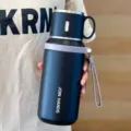 Vista detallada del termo de acero inoxidable 316 con infusor de té y correa de transporte portátil. - Negro
