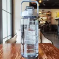 Grande borraccia sportiva con indicatore di tempo, citazioni motivazionali e manico. - Blu trasparente 2000 ml
