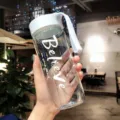Borraccia trasparente portatile con infusore e cinturino bianco in un ambiente di bar - 600ml / Blu trasparente - 600 ml