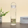 Transparente Kunststoff-Trinkflasche mit Silikontragegurt und Druckknopfdeckel, tragbare Variante. - 400ml