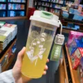 Transparente Plastik-Trinkflasche mit Maiglöckchen-Druck und grünem Trageriemen - Grünes Maiglöckchen