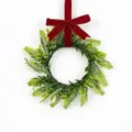 Detailed view of a handmade artificial Persian leaf wreath featuring a vibrant red velvet bow - Red Velvet Bow Style