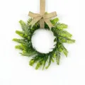 Detail view of an artificial Persian fern leaf wreath with a rustic burlap bow decoration. - Jute Burlap Bow Style