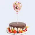 5-inch pink gold confetti balloon cake topper on a decorated chocolate cake. - Gold Pink