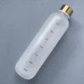 Close-up detail of frosted plastic water bottle with time markers and a shiny gold cap. - 1,000ml (Time Scale) / Pure White
