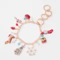 Detailed view of a gold-finish Christmas charm bracelet featuring enamel snowflake and reindeer - Christmas Bracelet