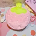 Close-up of a pink plush strawberry-shaped cosmetic bag with soft fuzzy texture. - Pink Strawberry Style