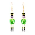 Detailed view of festive green nutcracker Christmas drop earrings with gold hooks. - Green Nutcracker