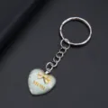 Detailweergave van een hartvormige sleutelhanger met MOM-tekst en gouden strikje - Blauwe Vlinder MOM Stijl (YSL-2)