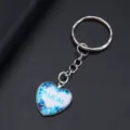 Detail van hartvormige sleutelhanger met blauwe vlinders en MOM-tekst - Hemelblauwe Vlinder MOM Stijl (YSL-9)