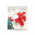 Christmas themed red bow hair clip with silver star decoration on a festive card - Bow and Star Style