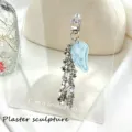 Detail view of a glittery blue angel wing and silver star chain keychain pendant - Blue