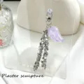 Close-up detail of purple glitter angel wing and cascading silver star metal chains - Purple