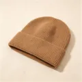 Nahaufnahme einer dicken Strickmütze mit Rippstrickmuster in Khakifarben - Rippenstrick-Umschlagmütze / Dunkelbeige