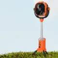 Portable camping fan with tripod stand, large battery capacity and LED light for outdoor use. - Vibrant Orange / English Version