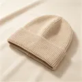 Nahaufnahme einer weichen beige gerippten Strickmütze für winterliche Wärme - Rippenstrick-Umschlagmütze / Hellbeige