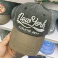 Detailaufnahme einer verwaschenen Baumwoll-Basecap mit New York Stickerei im Vintage-Stil - Distressed Baseballkappe / Schwarz