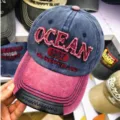 Detail der OCEAN Stickerei und des Lederbesatzes auf der verwaschenen Baseballkappe. - 55-60cm / Weinroter Schirm (OCEAN)
