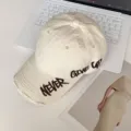 Primer plano de una gorra de béisbol de algodón desgastado beige con bordado detallado. - Estilo Americano Distressed (20240229) / 55-60cm / Beige