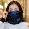 Scaldacollo multifunzionale blu e nero con motivo geometrico indossato da una modella - Stampa Stella a Spirale Blu / Regolabile / Blu